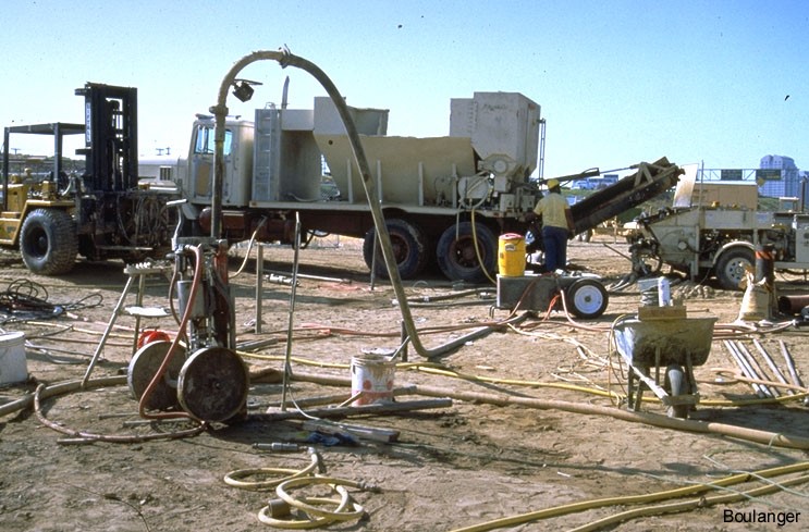 Grout lines run from the pump to the casing installed in the ground. The casing is held in place by a hydraulic jack.<br />(Courtesy of Dr. Ross Boulanger, UC Davis).