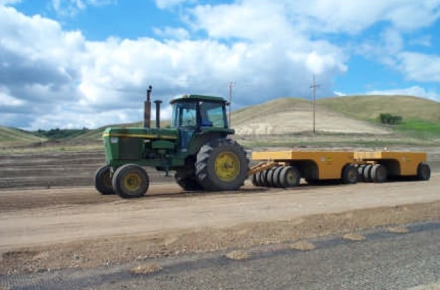 Compaction of base material on top of the geogrid. Courtesy of the North Dakota DOT.