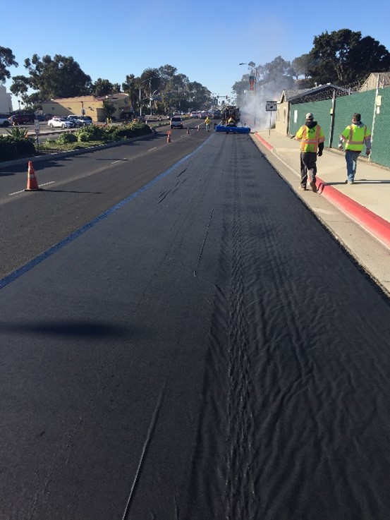 Placing GlasPave paving mat on project.