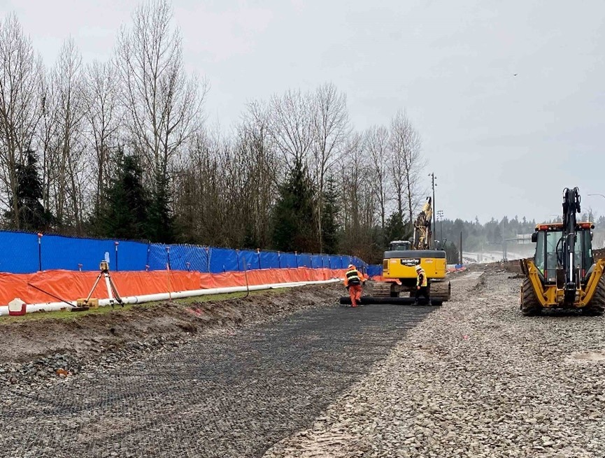 Placement of geogrid over aggregate surface
